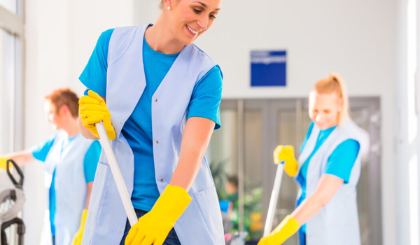 Office Cleaner team mopping and sweeping a bright hallway